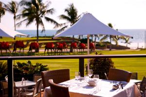 
a table with chairs and umbrellas in front of a beach at Cable Beach Club Resort & Spa in Broome

