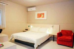 1 dormitorio con 1 cama y 1 silla roja en Jinjiang Inn Dongguan Nancheng Xiping Subway Station, en Dongguan