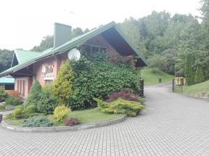ein Haus mit einem grünen Busch davor in der Unterkunft ,,Įlanka" in Rumšiškės