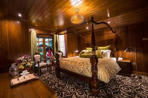 1 dormitorio con 1 cama y pared de madera en La Grande Villa, en Nuwara Eliya