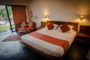 a bedroom with a large bed and a living room at Shangri-La Village Resort, Pokhara in Pokhara