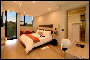 ein Schlafzimmer mit einem großen Bett, einem Schreibtisch und einem Tisch in der Unterkunft The Lakes Boutique Lodge in Pretoria + 71 Fotos