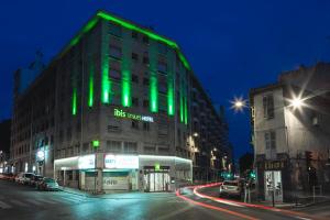 un edificio verde en una calle de la ciudad por la noche en ibis Styles Marseille Centre Prado Castellane, en Marsella