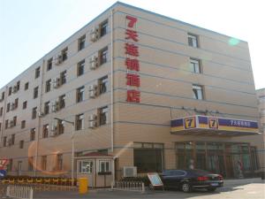 a building with a car parked in front of it at 7Days Inn Beijing Laiguangying in Beijing