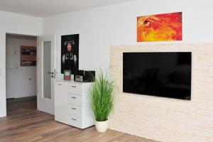 sala de estar con TV de pantalla plana en la pared en Ferienwohnung Bollenhut, en Schluchsee