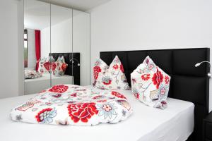 a bedroom with a bed with red and white pillows at Ferienwohnung Bollenhut in Schluchsee