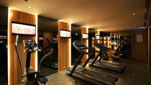 a gym with a row of treadmills and cardio machines at H2O HOTEL in Kaohsiung