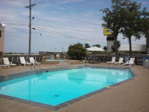 a large blue swimming pool with chairs around it at Quail's Nest Inn & Suites in Osage Beach