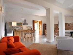 パッティにあるBelvilla by OYO Casa Ciceroのリビングルーム(オレンジ色のソファ付)、キッチンが備わります。