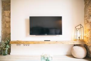 a living room with a television on a wall at Flateli- Plaça Catalunya 2-1 in Girona