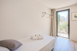 a bedroom with a large white bed and a window at Flateli- Plaça Catalunya 2-1 in Girona