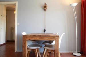 een houten tafel met stoelen en een klok aan de muur bij Cozy & Central | Palma B in Crans-Montana