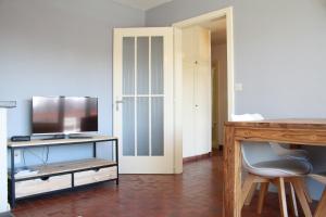 een woonkamer met een flatscreen-tv op een standaard bij Cozy & Central | Palma B in Crans-Montana