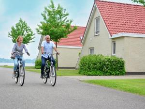 een man en een vrouw fietsend in een straat bij Maaspark Boschmolenplas - Waterblik in Heel