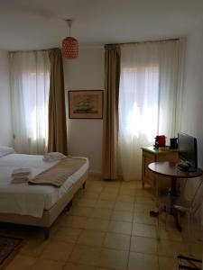 una camera con letto e scrivania con computer di Butterfly Guest House a Venezia