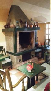 a living room with a stone fireplace and a table with a table sidx sidx sidx at Hotel Mance in Brod na Kupi