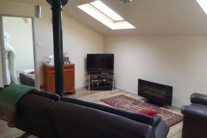 a living room with a couch and a flat screen tv at Stone Eater in Marsden