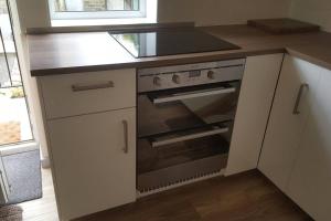 a kitchen with a stove and a counter top at Stone Eater in Marsden
