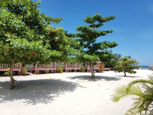 a park with trees and a building on the beach at Nice Sea Resort in Srithanu