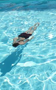a woman swimming in a pool of water at Camping Domaine Sainte Madeleine in Sospel