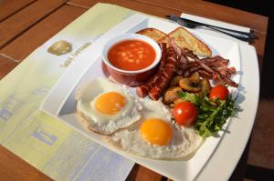 a plate of food with eggs and bread and beans at Hotel Saint Germain in Brăila