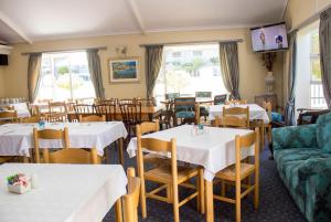 a restaurant with tables and chairs and a couch at The Russel Hotel in Knysna