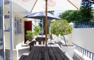 een houten tafel met een parasol op een patio bij The Russel Hotel in Knysna