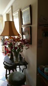 un jarrón de flores sobre una mesa con una lámpara en Great Danes Country Inn, en Swaffham