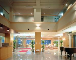 a large lobby with a piano in a building at Saito Hotel in Ueda
