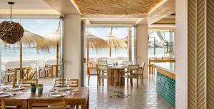 a dining room table with chairs and umbrellas at Nobu Hotel Ibiza Bay in Talamanca