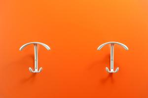 two metal hooks on an orange background at Hotel Mediterraneo in Sottomarina