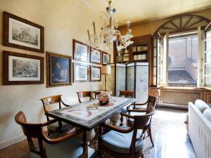 ボローニャにあるUR-NEST Strada Maggioreのダイニングルーム(テーブル、椅子、シャンデリア付)