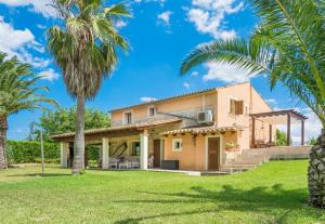 a house with palm trees in front of it at Can Corro in Alcudia