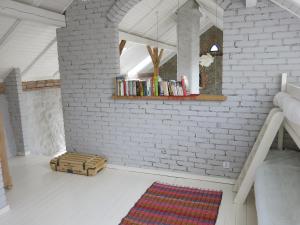 a room with a brick wall and a shelf with books at Krzywe 3 in Krzywe