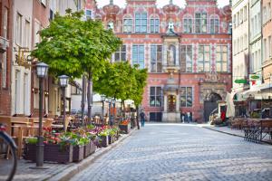 a cobblestone street in front of a large building at Euro Apartments Piwna in Gdańsk