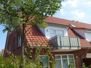 een rood bakstenen huis met een balkon bij Appartement Stader Str. 3 in Cuxhaven