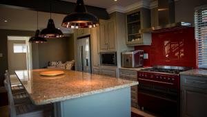 a kitchen with a granite counter top and red cabinets at Knysna Forest View in Knysna