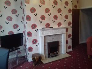 a living room with a fireplace with flowers on the wall at Crown Spa Apartment 13 in Scarborough +3 photos