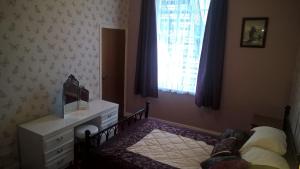 a bedroom with a bed and a dresser and a window at Crown Spa Apartment 13 in Scarborough