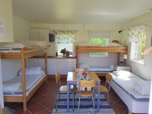 een kamer met een stapelbed en een tafel en stoelen bij Freja Vandrarhem in Vreta Kloster