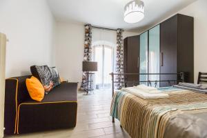 a bedroom with a bed and a couch and a mirror at Bologna Butterfly Apartment in Bologna