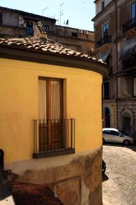 - un bâtiment jaune avec une fenêtre et un balcon dans l'établissement L'albero di Giuggiole, à Cosenza