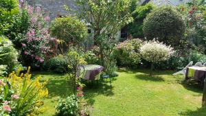 un jardín con un ramo de flores y mesas en Les Hirondelles en Sainte-Suzanne