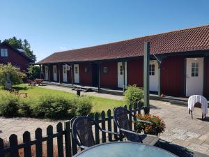 een tafel en stoelen voor een rij rode gebouwen bij Freja Vandrarhem in Vreta Kloster