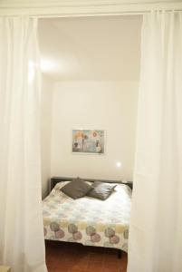 カターニアにあるCla & Ale Apartmentのベッドルーム(白いカーテン付きのベッド1台付)