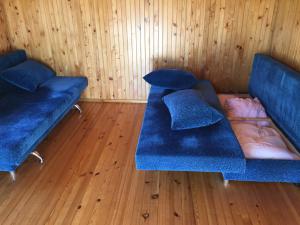 two blue seats in a room with wooden floors at Antano Razgaus kaimo turizmo sodyba in Plateliai
