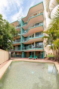 an apartment building with a swimming pool in front of it at Bayview Harbourview Apartments in Mooloolaba