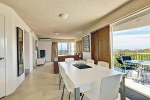 a living room with a white table and chairs at Bayview Harbourview Apartments in Mooloolaba