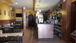 restauracja z barem oraz kilkoma stołami i krzesłami w obiekcie La Gallega w mieście Cacabelos
