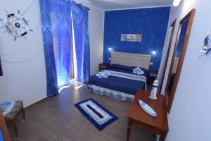 a blue bedroom with a bed and a table at B&B Empedocle in Porto Empedocle